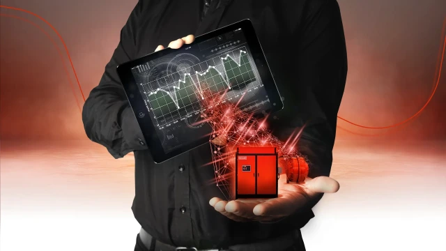一位男士的躯干，其一只手持有显示图表的 iPad，另一只手持有 Hägglunds 驱动系统
