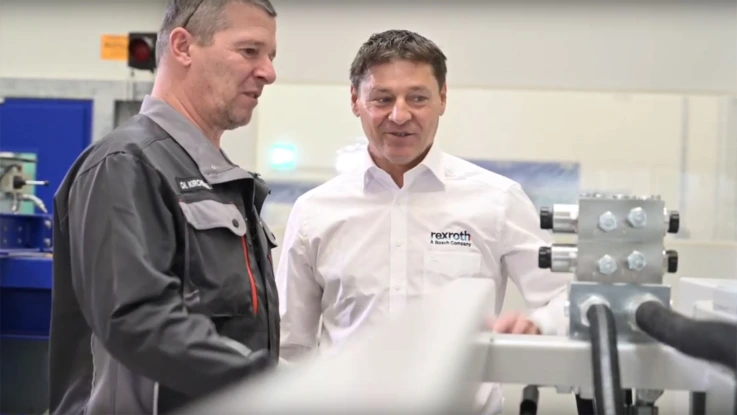来自 Wittmann Battenfeld 和 Bosch Rexroth 的两名员工正在查看液压系统直列板。