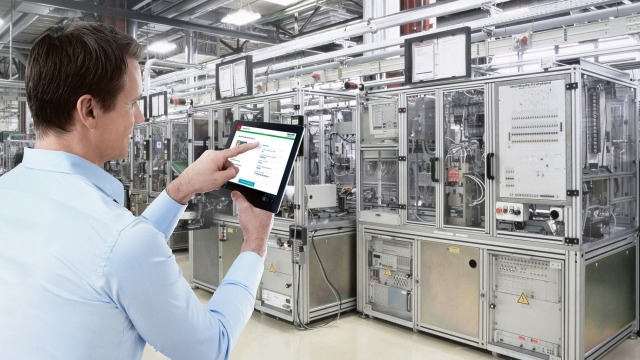 一人正在技术系统前的平板电脑上使用数字服务助手 (Digital Service Assistant)。