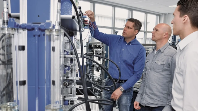 培训师向参与者演示液压训练设置的工作原理。工业液压培训课程链接。