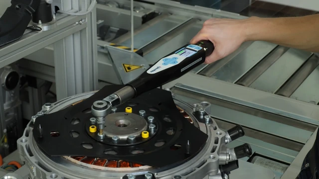 一名装配工在装配工作站使用博世力士乐角形螺丝刀拧紧面板。紧固技术培训课程链接